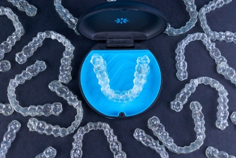Several Invisalign clear aligners in Lenox with one set in their carrying case