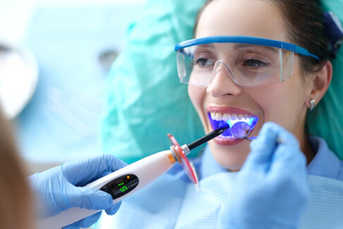 A dentist performing a cosmetic dnetal bonding treatment