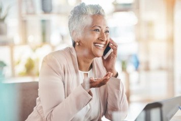 Happy gray-haired woman speaking on the phone