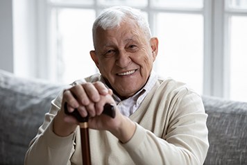Senior man sitting on couch and smiling