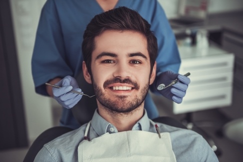 Young man in dental chair smiling at Lenox dental office