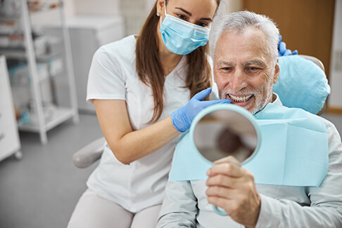 An older man happy with his newly-placed dental implants