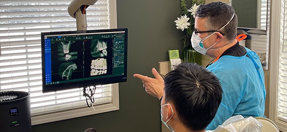 Doctor Young and dental patient looking at x rays of teeth