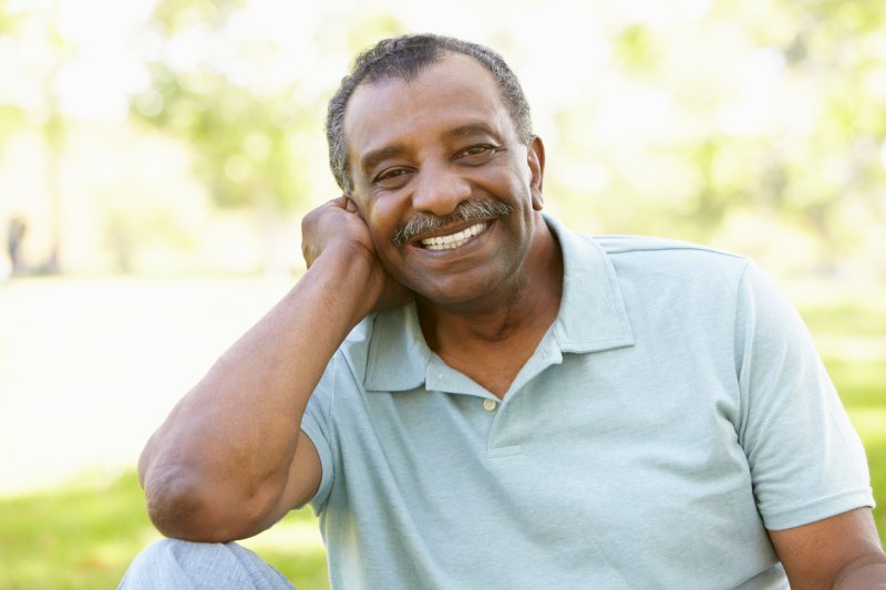 Older patient smiling with dentures after using denture adhesive